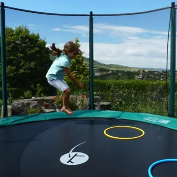 Cama elástica con red y niño